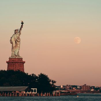 Statue of Liberty and full moon at sunset in New York City